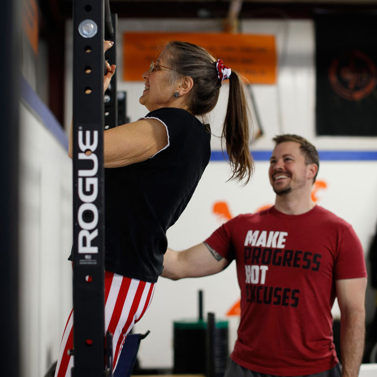 Linda doing a pull-up with trainer Adam Schaeuble